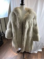 Full front view of cream fur jacket on mannequin