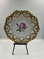 Front view of full plate on stand showing rose motif and gilt border