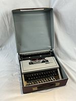 Olivetti Underwood portable typewriter inside the open brown carrying case focusing on the mechanism and keyboard.