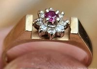 Top-down view of ring showing ruby center and diamond cluster on yellow gold band