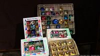 Photo showing various vintage Christmas balls separated by color and stored in original cardboard trays and boxes.