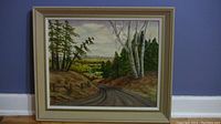 Framed oil painting showing entire artwork titled 'Kaministiquia River and Valley,' depicting a rural Canadian landscape with trees and a winding road.