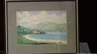 Full view of framed watercolor showing landscape scene, neutral mat, and wood frame.
