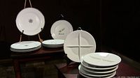 14 plates displayed, 6 four-section canapé plates, 4 plates with snowflake design, 4 with fashion image design.