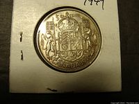 Reverse side of the 1949 Canadian 50 cent coin with the Canadian Coat of Arms and denomination details.