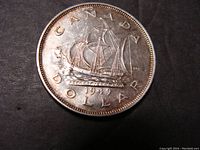 Reverse side of the 1949 Canadian silver dollar featuring the Bluenose schooner and inscriptions including year 1949.