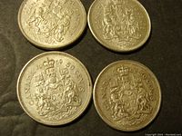 Four Canadian 50 cent silver coins dated 1959, 1961, 1962, and 1963 showing the Canadian Coat of Arms