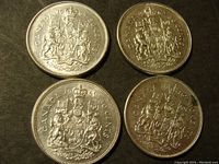 Obverse side of four Canadian 50 cent silver coins dated 1961, 1963, 1964, and 1965 showing the Canadian coat of arms.