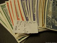 Stack of various denominations of CTC scrip currency with a small note showing calculations verifying total $19.25 face value.