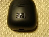 Top view of the black charging case with JBL logo and USB-C charging port.