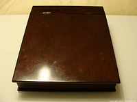 Closed lap writing desk with dark wood finish, showing scuffing on lid surface.