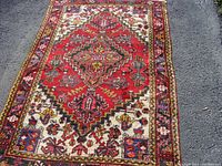 Top view of the entire Persian rug showing central red diamond medallion and floral surrounding pattern
