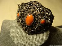 Front view showing large central coral and filigree detailing