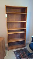 Front view of the wood bookcase showing five shelves and wood grain finish.