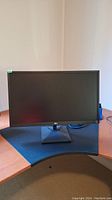 Front view of the LG 27-inch monitor on a desk with black base stand and matte screen off. Shows the full monitor size and screen shape.