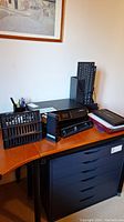 Photo showing HP DeskJet 4520 printer, IBM keyboard, file holders, pen holder cup with stationery on a wooden desk.