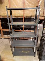 Front view of metal 5-shelf storage unit showing five flat metal shelves and vertical frame with adjustable holes.
