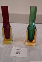 Pair of Murano glass bud vases, one red and one green, showing front view and colors
