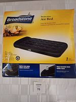 Photo of the box packaging showing broadstone brand twin-size air mattress with built-in foot pump and highlighting features such as non-slip surface, recycled PVC material, and pump integration.