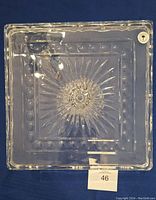 Top view of square lead crystal cake stand showing starburst center and decorative dot border.