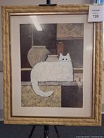 Framed print showcasing a white cat resting on a shelf with several vases behind it, all in neutral-earth color tones. The print is within a textured wooden frame.