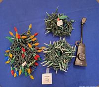 Overview of three bundled C9 colorful Christmas light strings and one black electrical timer with dial and plug