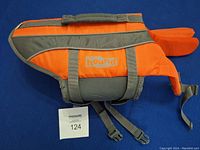 Side view of the orange and gray dog life vest showing the 'Hound' brand and adjustable straps.