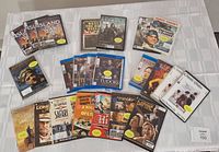 Photo of 23 DVDs laid out on a table showing a variety of titles including 'Island at War', 'The Tudors', classic comedies, and others.
