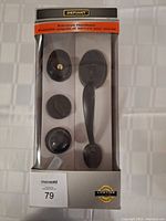 Front view of Defiant entrance handle set in original packaging showing black handles and lock components