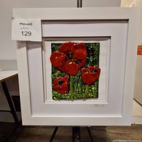 Framed textured art with red poppies in a white frame.