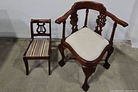 Two antique chairs together showing the lyre back side chair and ornately carved corner armchair