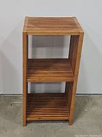 Front view of the 2-shelf bamboo plant stand showing three levels of slatted shelves and rectangular shape
