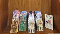 Detailed image of the packaged Beanie Babies and the Beanie Baby Handbook showing Maple, Erin, Brittanna, and Glory Beanie Babies in original packaging