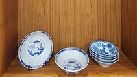 Set of 2 large Asian blue and white ceramic soup bowls with landscape design and 4 smaller blue and white floral Asian bowls stacked