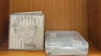 The fold-out case of Woody Guthrie Centennial Collection 3 CD set and plastic container with stamps.