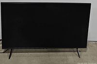 Front view of a Samsung 38 inch LED TV powered off showing screen and angled stand legs.