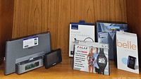 Full lot displayed with original packaging including Sony docking system, Garmin navigation, Insignia Bluetooth headphones, Belle wireless mobile, and Polar heart rate monitor.