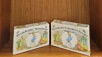Two boxes displayed side by side labeled Peter Rabbit Nursery Set and Children's Tea Set by Wedgwood, resting against a wooden backdrop.