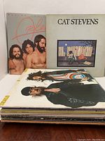 Photo showing a stack of 13 vinyl LP albums from various artists, focused on Orleans, Cat Stevens, and Seals and Crofts albums with visible cover art.