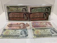 Four 1 dollar bills and four 2 dollar bills displayed together inside protective sleeves showing variety and condition.