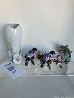 Porcelain vase with hummingbird motif at base and two bird figurines on branches with flowers