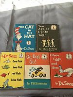 Five children's books arranged on a grey background, showing front covers with colorful illustrations and titles.