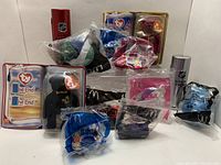 Photo showing various McDonald's toys in original unopened packaging including Ty Beanie Babies, SEGA Sonic, and NHL toys arranged closely.