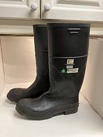 Side view of men’s black steel toe rain work boots showcasing tall construction and durable sole.