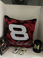 Dale Earnhardt Jr. #8 pillow with signature, small framed signed Davey Allison photo, two small white diecast racing cars, and blue Jimmy Johnson #24 stein.