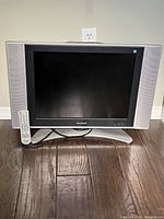 Front view of the Sharp 20 inch flat screen television with remote placed in front