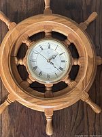 Full view of the oak ship wheel clock showing the wooden frame and clock face