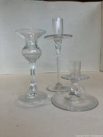 Photo of three crystal candlestick holders showing varying heights and styles including wide flared rim and twisted stem.