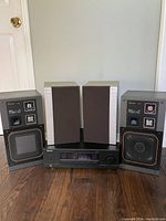 Front view showing Sherwood stereo receiver with Mitsubishi speakers placed on top and sides.