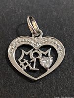 Close-up of the 10K gold heart-shaped pendant with 'MOM' text and stones set in the design.